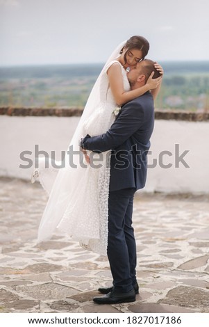Groom and bride stand in front of city view