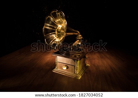 Music concept. Old gramophone on a dark background. Retro gramophone with disc on wooden table with toned backlight. Selective focus