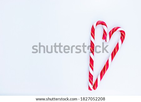 Candy cane in the shape of the heart with white space for text. Flat lay, top view.