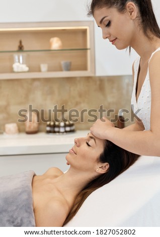Cosmetician working at beauty parlour, massaging face.