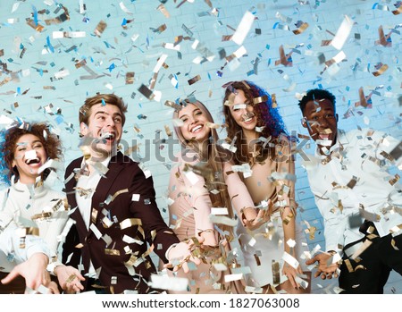 Party People. Happy Friends Having Fun Partying Enjoying Falling Confetti Celebrating New Year Indoor