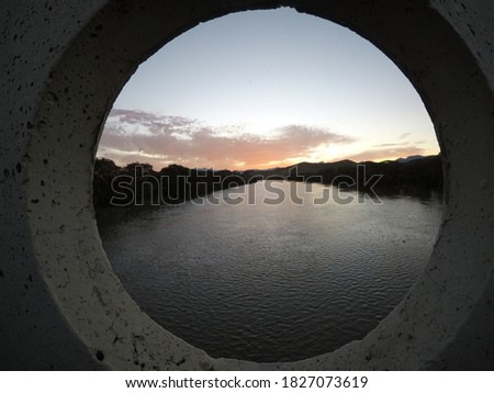 
river passing by bridge at sunset