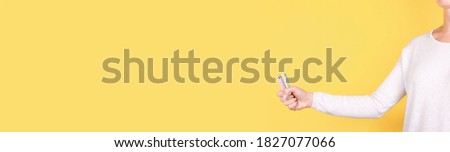 Hand with colored birthday candles. Isolated on yellow background, copy space template, banner.