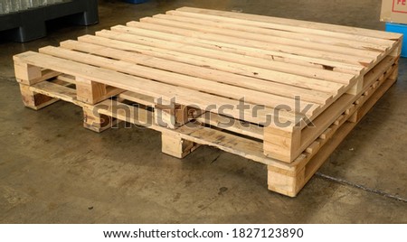 Brown pallet wood, good condition, stacked 2 floors on the concrete floor in the factory, waiting for the product to be placed and lifted for further storage.