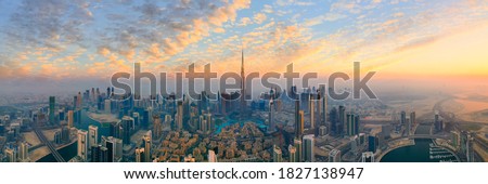Amazing panoramic view of Dubai skyline showing the world's tallest building building in Dubai during sunset vibrant skies with clouds in futuristic city downtown; Perfect travel destination panorama