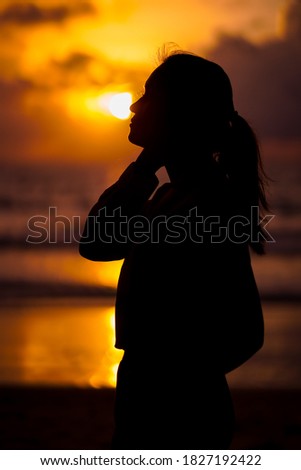 Asian woman silhouette at the beach.