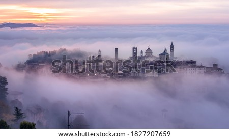 Bergamo Città Alta shrouded in fog on a foggy winter morning, this is the oldest part of medieval Bergamo, Lombardy, Italy. Royalty-Free Stock Photo #1827207659