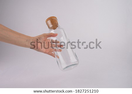 Hand holding glass bottle isolated on white background