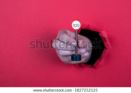Speed limit sign concept. Road sign in a woman's hand. Red background. Copy space