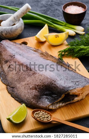 Raw fresh halibut without head on wooden cutting board
