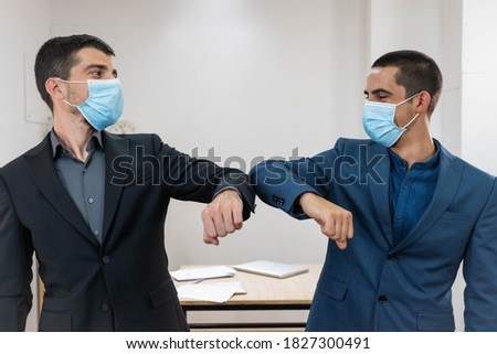 Coronavirus. Business workers elbow greeting in a white background. Elbow greeting because coronavirus. Business workers back to work in office after lockdown. Royalty-Free Stock Photo #1827300491