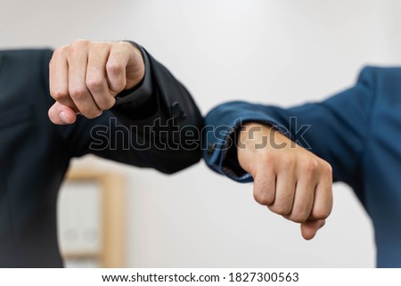 Coronavirus. Business workers elbow greeting in a white background. Elbow greeting because coronavirus. Business workers back to work in office after lockdown. Royalty-Free Stock Photo #1827300563