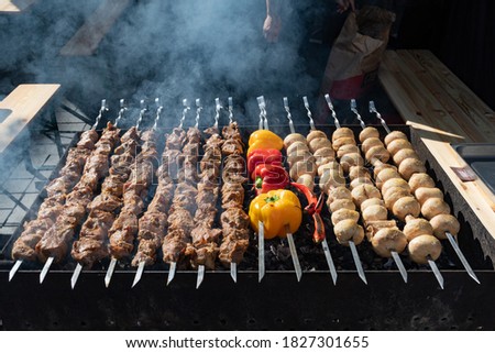Close up of meat skewers, grilled in a barbecue, shashlik or shashlyk, with peppers, paprika and mushrooms, street market, festival, fair