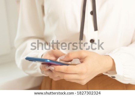 girl uses the phone at the table, looks at the news, mail, business concept