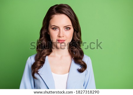 Photo of young calm woman curly hairstyle look camera wear blue jacket isolated green color background