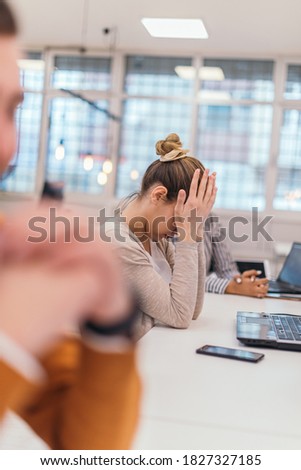 Portrait of a tired businesswoman  having a business meeting in the office. Royalty-Free Stock Photo #1827327185