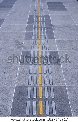 Blind pedestrian lane with yellow tactile paving. Symmetrical view.