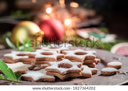 Homemade stained glass cookies as a small Christmas sweets on wooden table