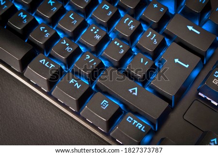 Black gaming keyboard with backlight. Close up. Selective focus