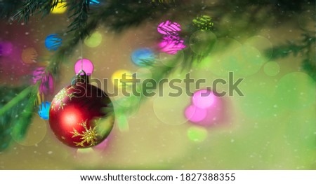 Christmas and New year magic bokeh background with red ball that hangs on a christmas tree branch. Festive banner with colorful lights and garland. Celebration concept. Copy space for text