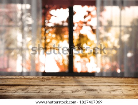 Empty wooden table near window on sunny autumn day