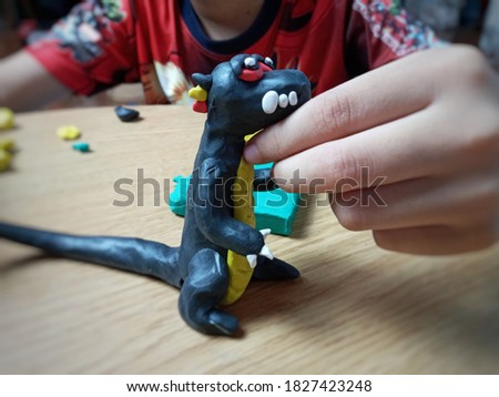 kid's hand making dragon from plasticine on table background.education activity for kids concept.