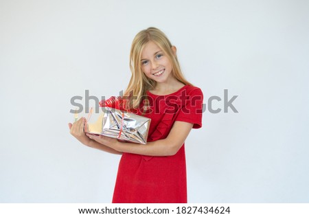Happy little smiling girl with christmas gift box.