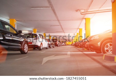 Guarded multilevel car parking in the shopping center, sunset. Copy space for text