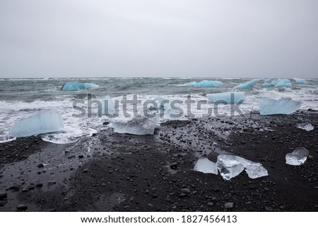 A mesmerizing view of Diamond Beach in Iceland with big pieces of glacial ice on the black sand
