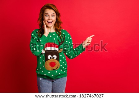 Photo portrait of excited woman with open mouth touching face with one hand pointing finger at blank space isolated on bright red colored background