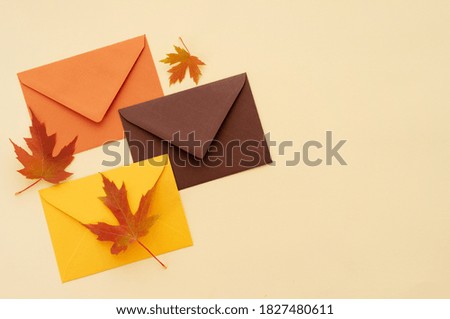 
three envelopes with autumn leaves on a light yellow background. Thanksgiving greeting card concept. Copy space