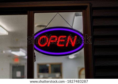Neon open sign in window at night, selective focus, background blur
