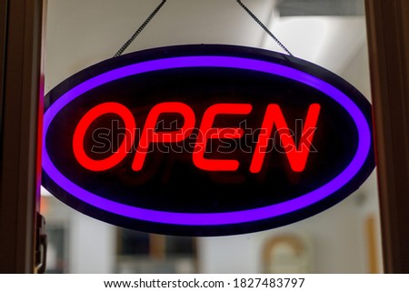 Close up of a neon open sign in window at night, selective focus, background blur
