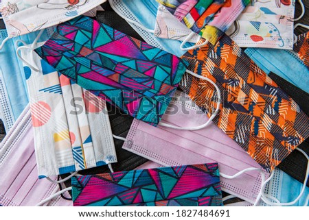A stack / pile of disposable colorful medical face masks (surgical masks 3 layers) for protection COVID-19 pandemic (coronavirus), saliva, cough, dust, pollution (PM2.5), virus and bacteria. Top view
