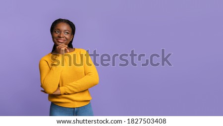 Nice Offer. Curious African American Woman Looking Away At Copy Space On Purple Background, Thoughtful Black Female Touching Chin, Thinking About Something And Playfully Smiling, Panorama Royalty-Free Stock Photo #1827503408