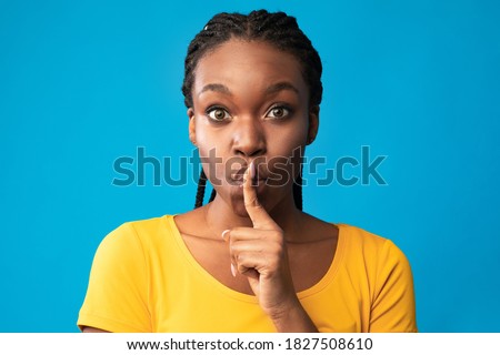 Hush Sign Gesture. African American Millennial Woman Gesturing Finger On Lips Posing Looking At Camera Standing Over Bright Blue Studio Background. Keep Silence And Secrets Concept.