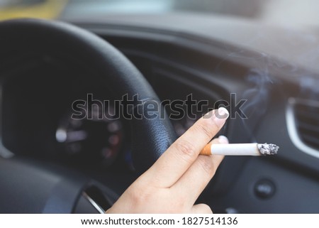 A picture of a woman smoking in a car