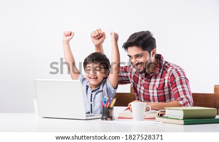 Indian kid studying online, attending school via e-learning with father Royalty-Free Stock Photo #1827528371