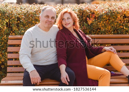 Beautiful smiling middle-aged couple in autumn. red-haired woman