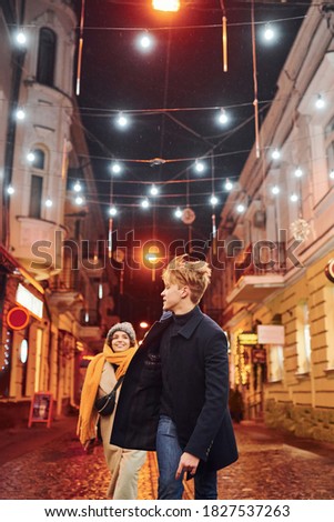 Couple have a walk together on the christmas decorated street.