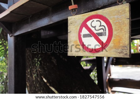 Wooden sign label of 'no smoke zone' that hanging under the floor