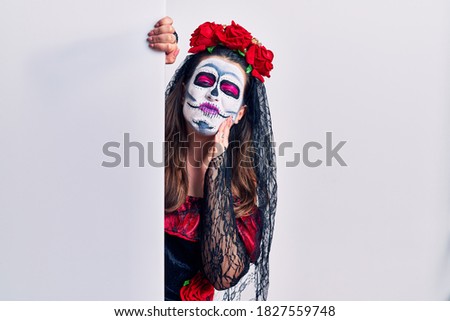 Young woman wearing day of the dead custome holding blank empty banner touching mouth with hand with painful expression because of toothache or dental illness on teeth. dentist concept. 