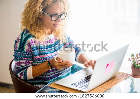 Smart work and alternative office worstation with modern people caucasian woman working at home or hotel with laptop computer and internet connection - enjoying free life with different workplace  Royalty-Free Stock Photo #1827566000