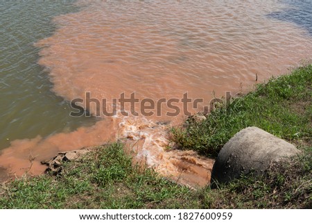 turbidity and clear water flow from concrete pipe Royalty-Free Stock Photo #1827600959
