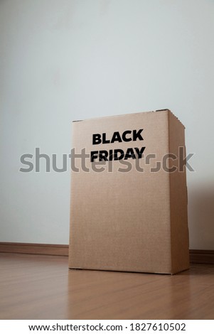 
Cardboard box with black friday order written on the box placed on the floor in an empty room with a neutral background. delivery concept. economy concept. black friday concept. shopping concept. 