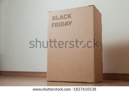 
Cardboard box with black friday order written on the box placed on the floor in an empty room with a neutral background. delivery concept. economy concept. black friday concept. shopping concept. 