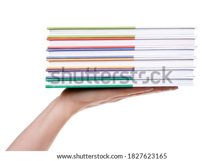 Hand with stack of colored books, isolated on white background.