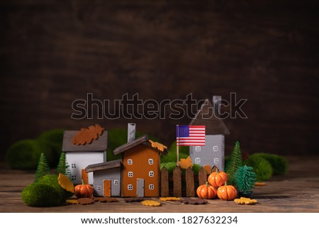 Miniature Thanksgiving Day little fairy autumn cottages, pumpkins, USA national flag, wooden background, postcard concept, toned