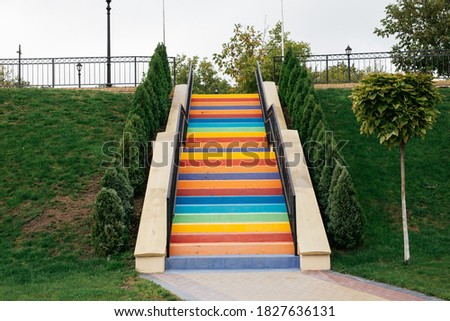 Rainbow stairs. Stairs painted in different colors surrounded by greenery in a park.
