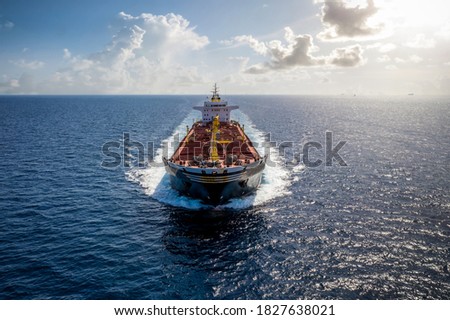 A bulk carrier freight ship traveling on full motion over blue sea Royalty-Free Stock Photo #1827638021